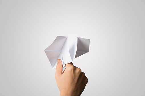 Woman hand Dart Paper Airplane isolated on white background.