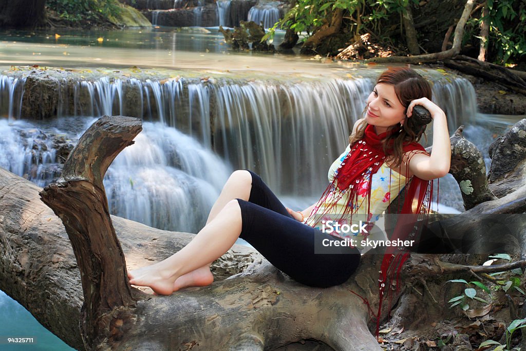 Fille couché dans tree contre les cascades - Photo de Adulte libre de droits