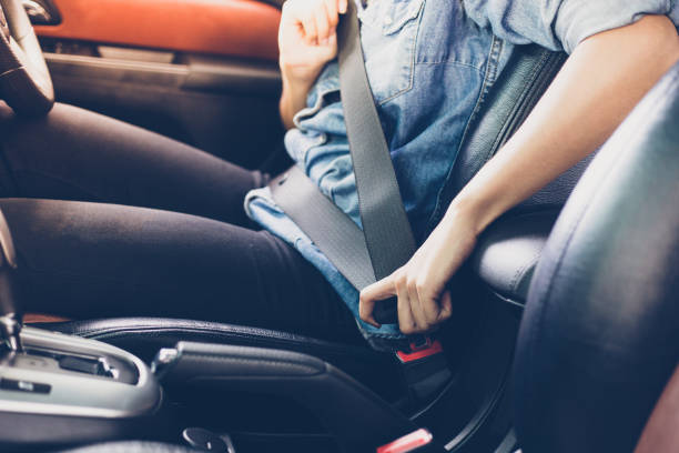 mujer asiática de fijación del cinturón de seguridad en el coche, el concepto de seguridad - middle of road fotografías e imágenes de stock