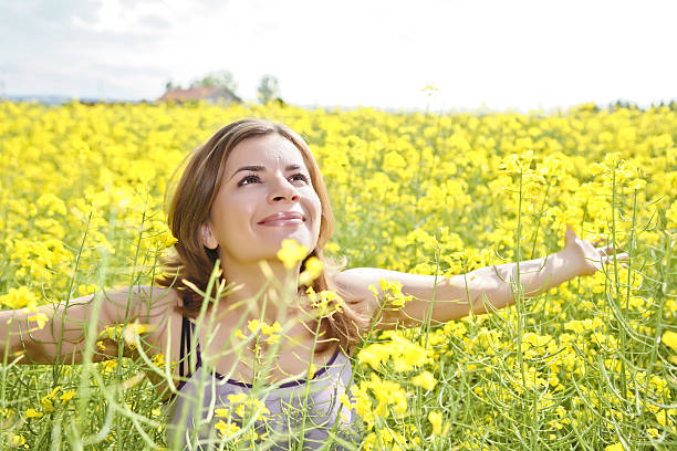 feliz chica en un campo amarillo. - cut flowers women field single flower fotografías e imágenes de stock
