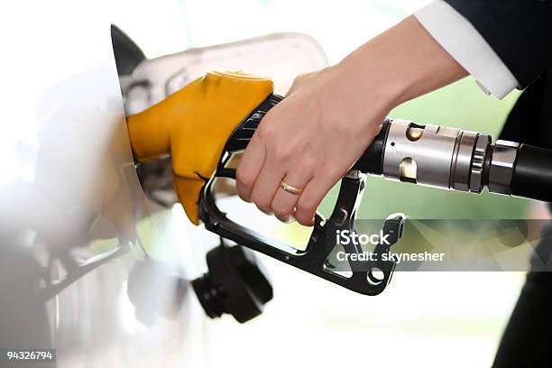 Mujer Echando Gasolina En Gas Station Foto de stock y más banco de imágenes de Adulto - Adulto, Adulto joven, Amarillo - Color