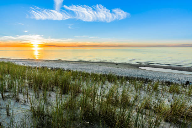 istock Sandy beach and sunset sky with golden sun shining on white sand 943279282