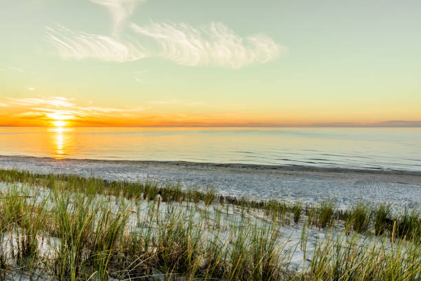 istock Sandy beach and sunset sky with golden sun shining on white sand 943279340