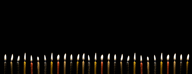 Many birthday candle with lighting in the darkness with copy space