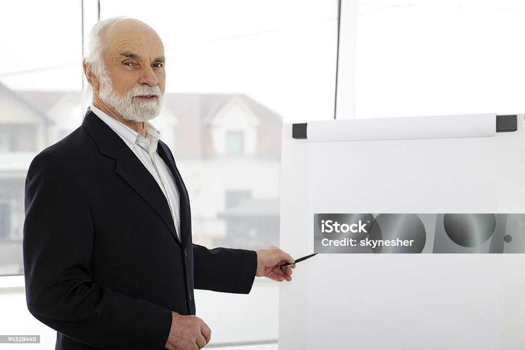 Sênior dando a apresentação em um flipchart. - Foto de stock de Seminário - Reunião royalty-free