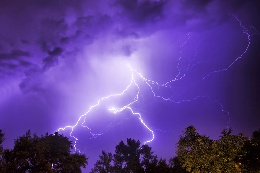 Dramatic thunderstorm lightning bolts in the night sky with copy space. Extreme weather concept or background.