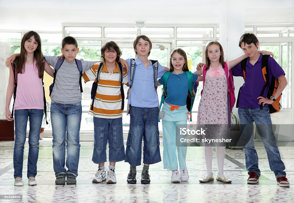 Schoolchildren standing in hallway.  Satchel - Bag Stock Photo