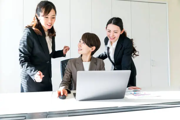 Photo of Three businesswomen working in the office. Positive workplace concept.