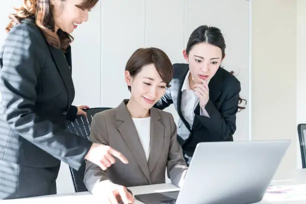 Photo of Three businesswomen working in the office. Positive workplace concept.