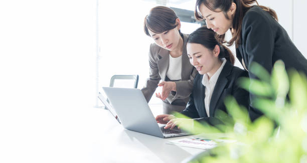 drei unternehmerinnen im büro arbeiten. positiven arbeitsplatzkonzept. - japanese ethnicity train women asian ethnicity stock-fotos und bilder