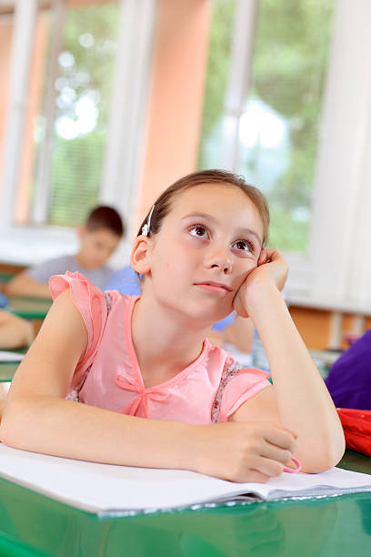 istock Cute school girl bored in the classroom. 94329154