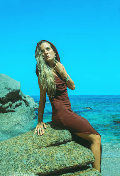 bella giovane donna che cammina lungo una spiaggia tropicale - wizards of the coast foto e immagini stock