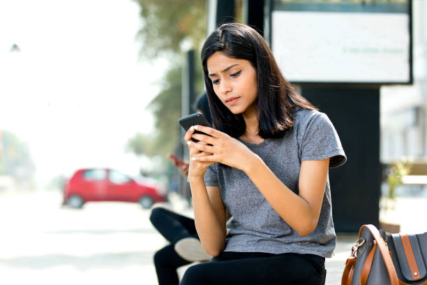 istock Woman using mobile phone on city street 943293332