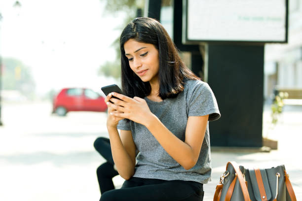 istock Woman using mobile phone on city street 943293424