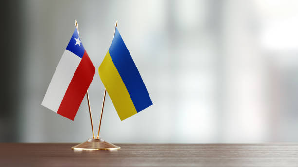 istock Chilean And Ukrainian Flag Pair On A Desk Over Defocused Background 943293492