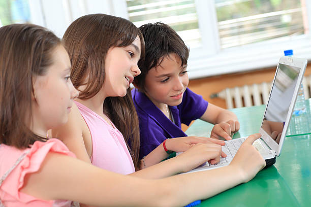 istock School children having fun on laptop at classroom. 94329358