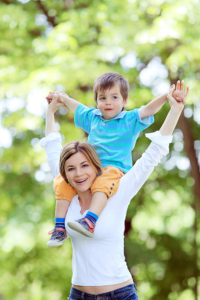 istock Mother holding her little son piggy-back. 94329392