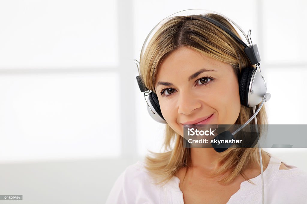 Młodego uśmiechającego się operatora z zestawu słuchawkowego. - Zbiór zdjęć royalty-free (Biały)