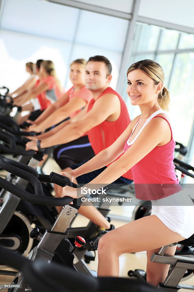 Personas en las bicicletas spinning en un gimnasio moderno. - Foto de stock de Actividad libre de derechos