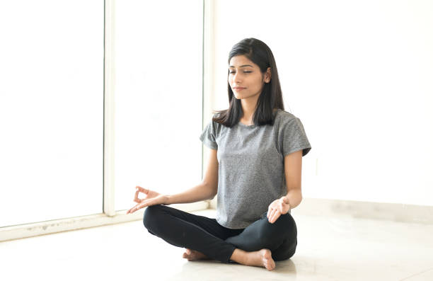 молодая женщина медитирует - sitting upright стоковые фото и изображения