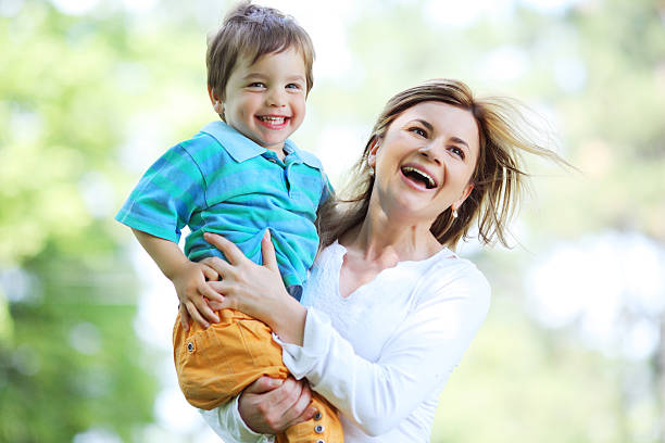 istock Happy mother with her cute little son running outside. 94329596