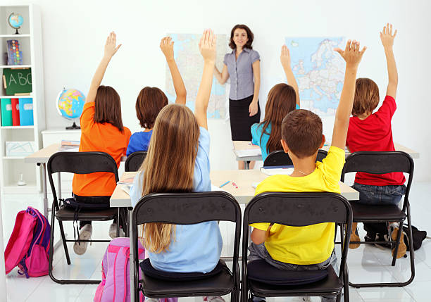 istock School children raising hands. View from behind. 94329744