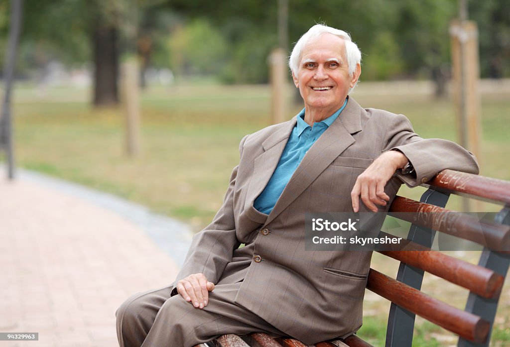 Radosny starszy mężczyzna siedzi na ławce na zewnątrz. - Zbiór zdjęć royalty-free (Człowiek dojrzały)