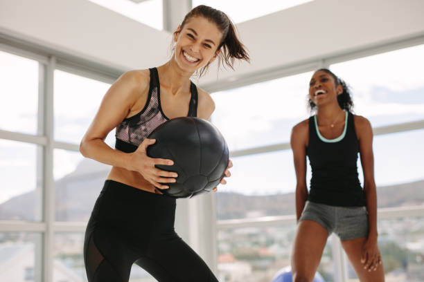 ragazze che si allenano in palestra con palla di medicina - friendship women exercising gym foto e immagini stock