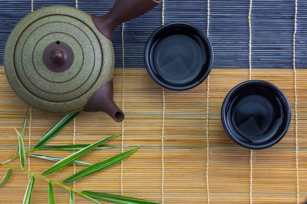 Japanese hot tea pot with cup on bamboo mat stock photo