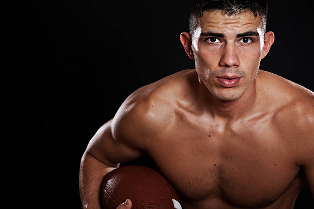A male tackle football player is ready to play the game.