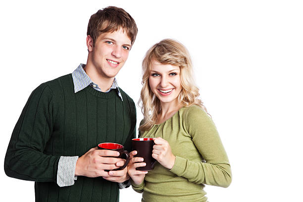 Cut out shot of unrecognizable couple having coffee and keeping their son company while sitting at dining table together.