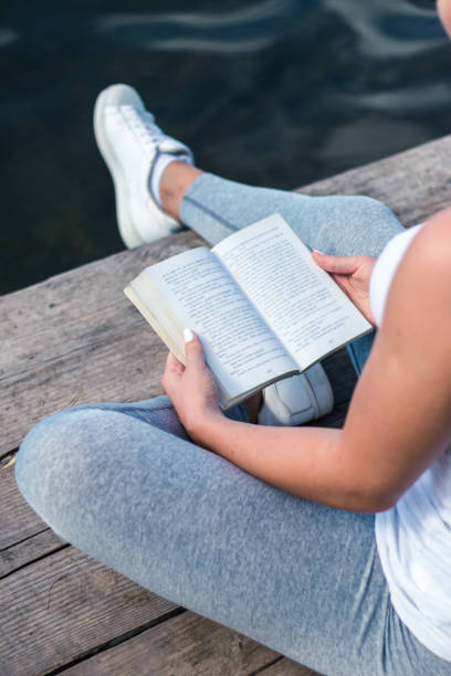 istock Woman relaxes by lake, reads a book 943316350