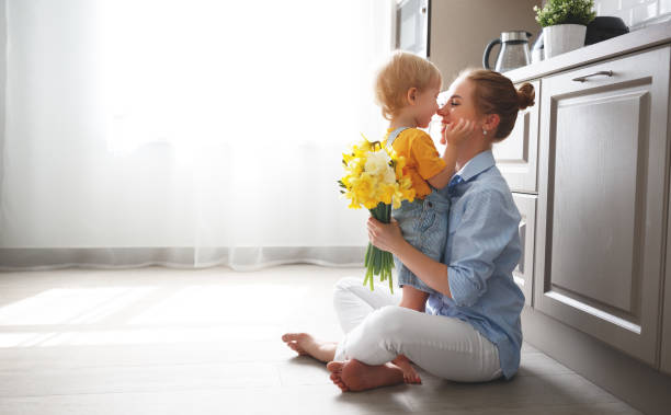 happy mother's day! baby son gives flowersfor  mother on holiday - small bouquet imagens e fotografias de stock