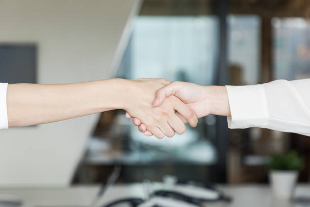 две женщины пожимают друг другу руки. концепция делового партнерства. - handshake women human hand business стоковые фото и изображения