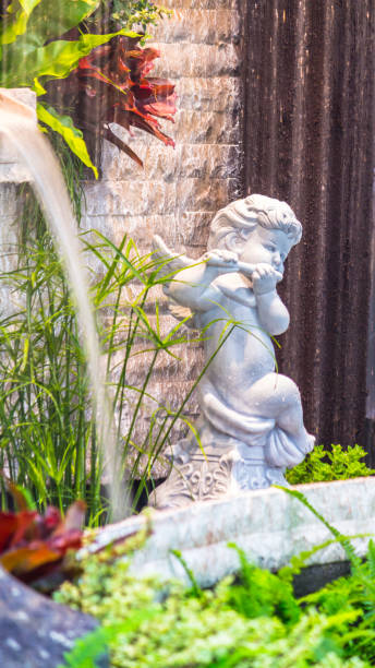 istock Statue of Cupid in cozy garden. 943330376