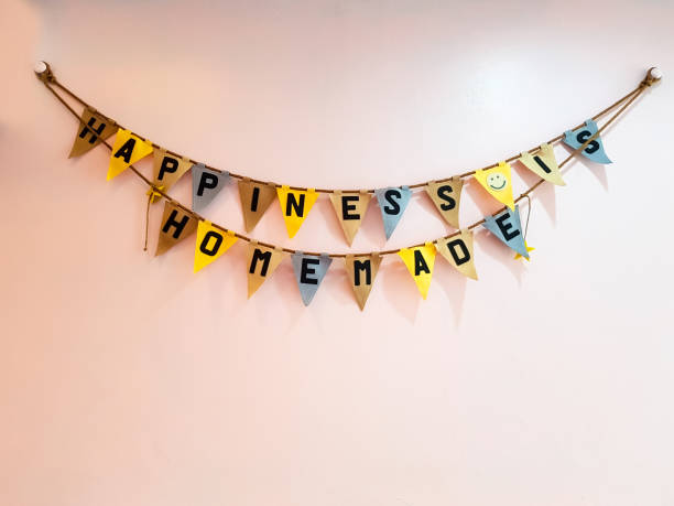 istock happiness is home made word on Triangular multi color flag hanging with rope on pink wall. can use for special occasion or party concept. 943335054