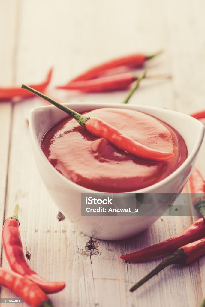 Red hot chilli sauce in white ceramic bowl Sriracha Tiger Zoo Stock Photo