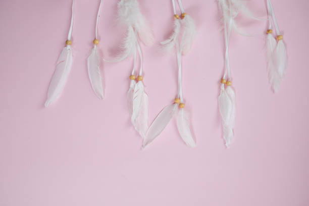 istock Spase for text. White dream catcher with feathers on a pink background. Freedom concept 943351242