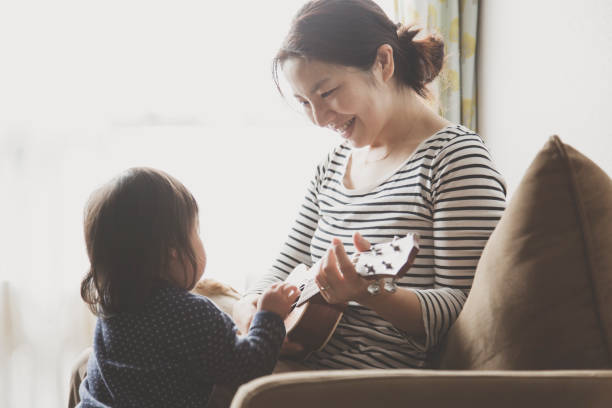 istock Mother and baby playing ukulele at home 943351884