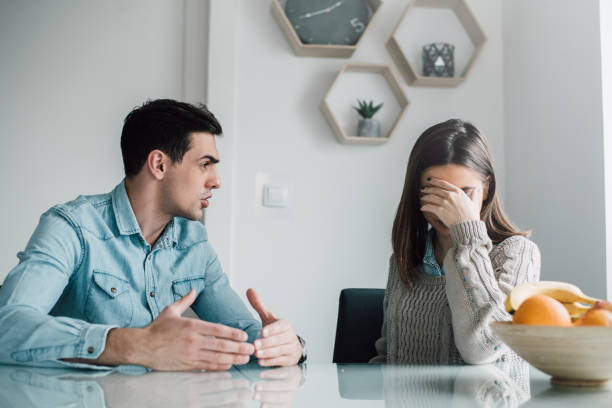 istock Man explaining his reasons for a fight, woman hiding her eyes 943354680