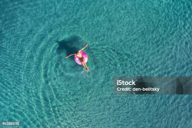 Aerial View Of Young Woman Swimming On The Pink Swim Ring In The Transparent Turquoise Sea At Sunrise In Thailand Summer Seascape With Girl Clear Water In The Morning Top View Travel And Holiday Stock Photo - Download Image Now