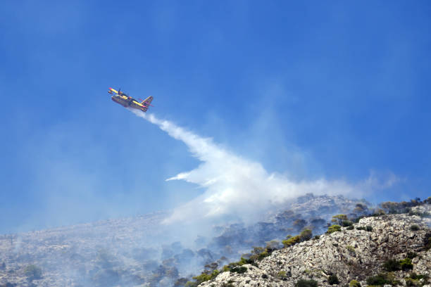 istock Firefighting plane extinguishes a fire on the hillside . Greece. 943365092