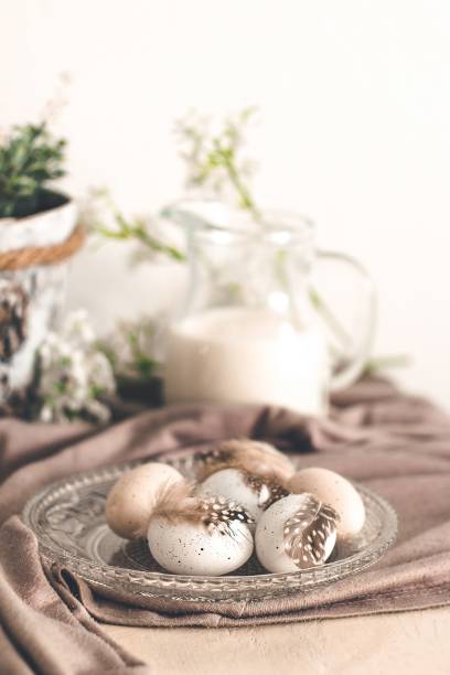 istock Beautiful pastel eggs with feathers with milk and spring flowers 943369228