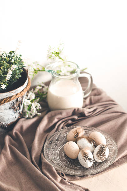 istock Beautiful pastel eggs with feathers with milk and spring flowers 943369248