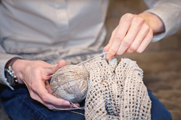 istock Male hands with linen threads and crochet. 943371878