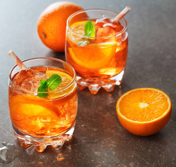 istock orange cocktail with ice, mint and orange slices on gray background 943374820