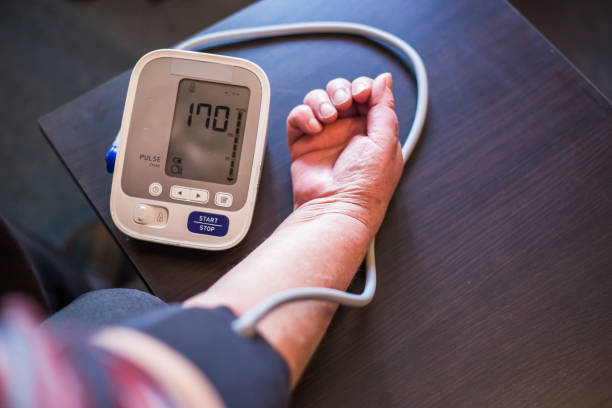 senior mujer mide la presión en casa - blood pressure bulb fotografías e imágenes de stock