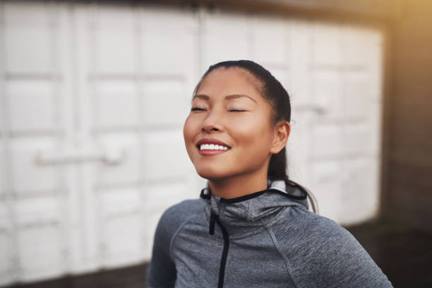 istock Smiling young Asian woman taking a break from her run 943383704