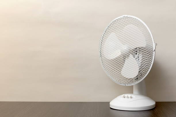 white desk oscillating fan, toned, copy space