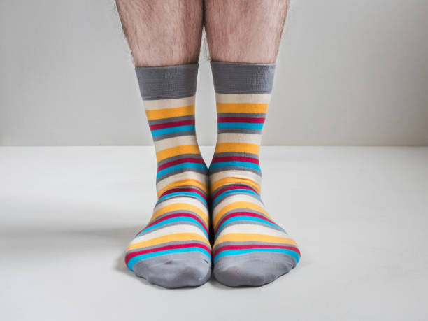 istock Men's feet in funny, colorful socks 943387938